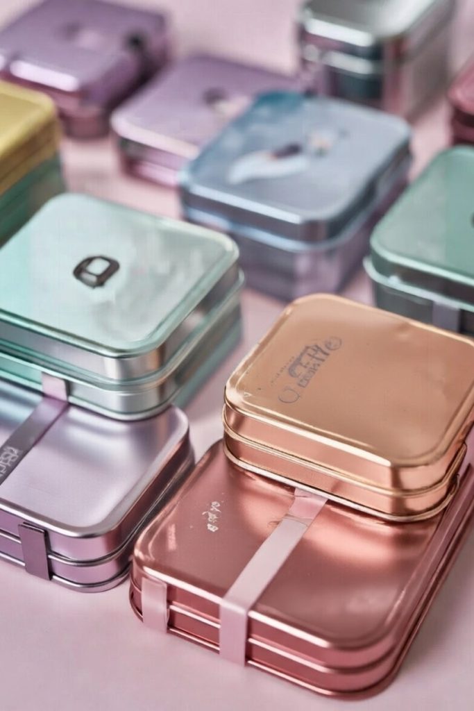 Modern pastel tin containers and aluminum-inspired gift boxes stacked for a ten year anniversary gift, combining classic tradition with contemporary style.
